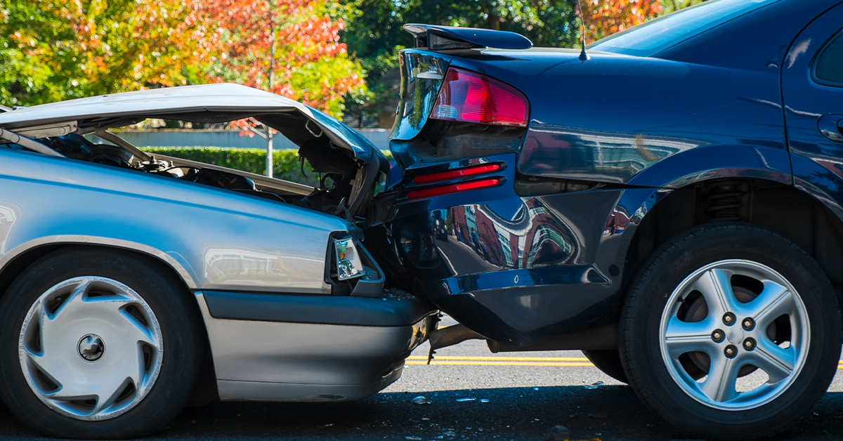 Rear-end collision between two cars on a city street, illustrating the blog topic What to Do After a Rear-End Collision